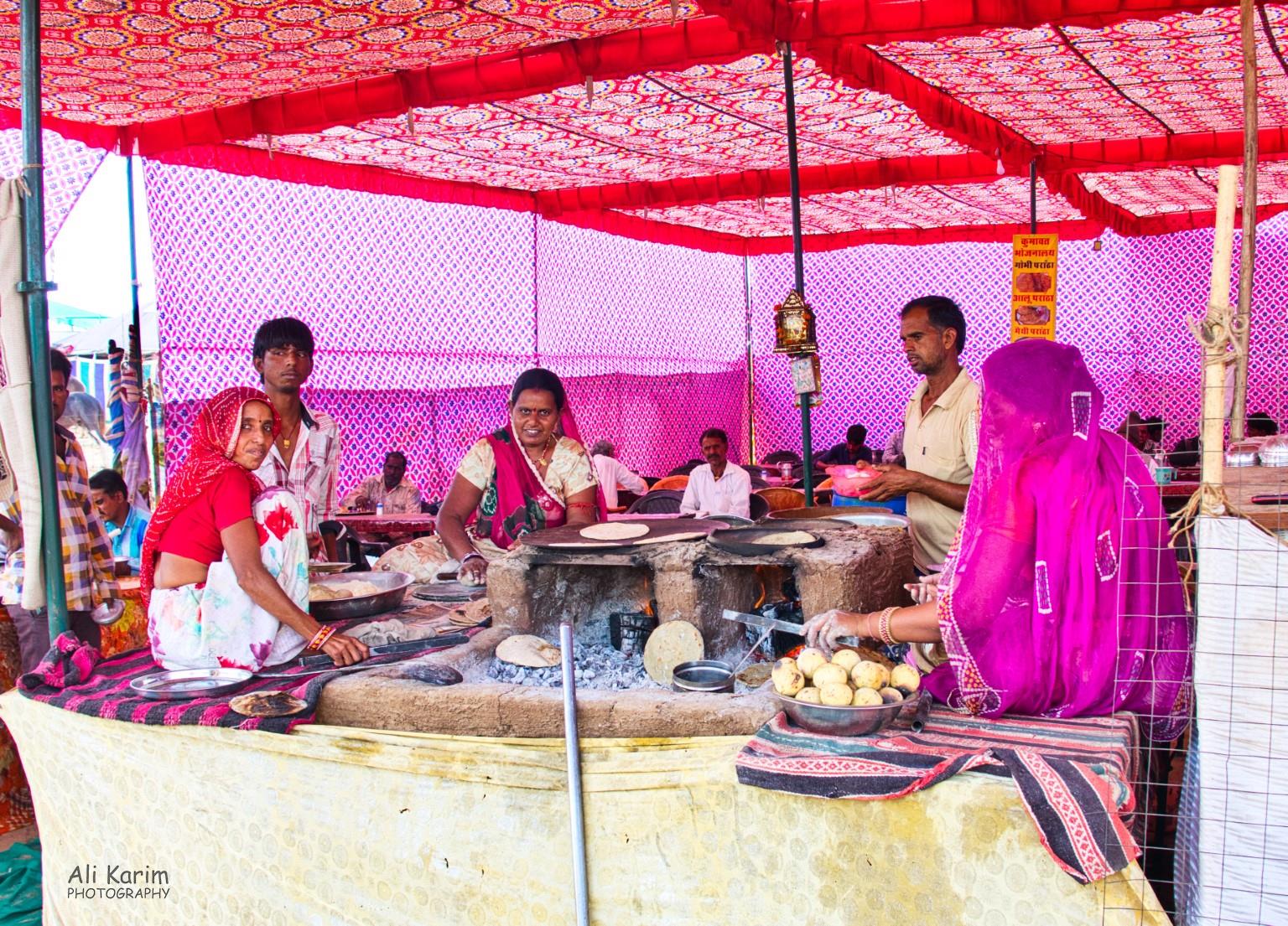 Food stall, with ladies making the typical Baati wheat balls, and baajra roti Pushkar, Rajasthan Food stall, with ladies making the typical Baati wheat balls, and baajra roti