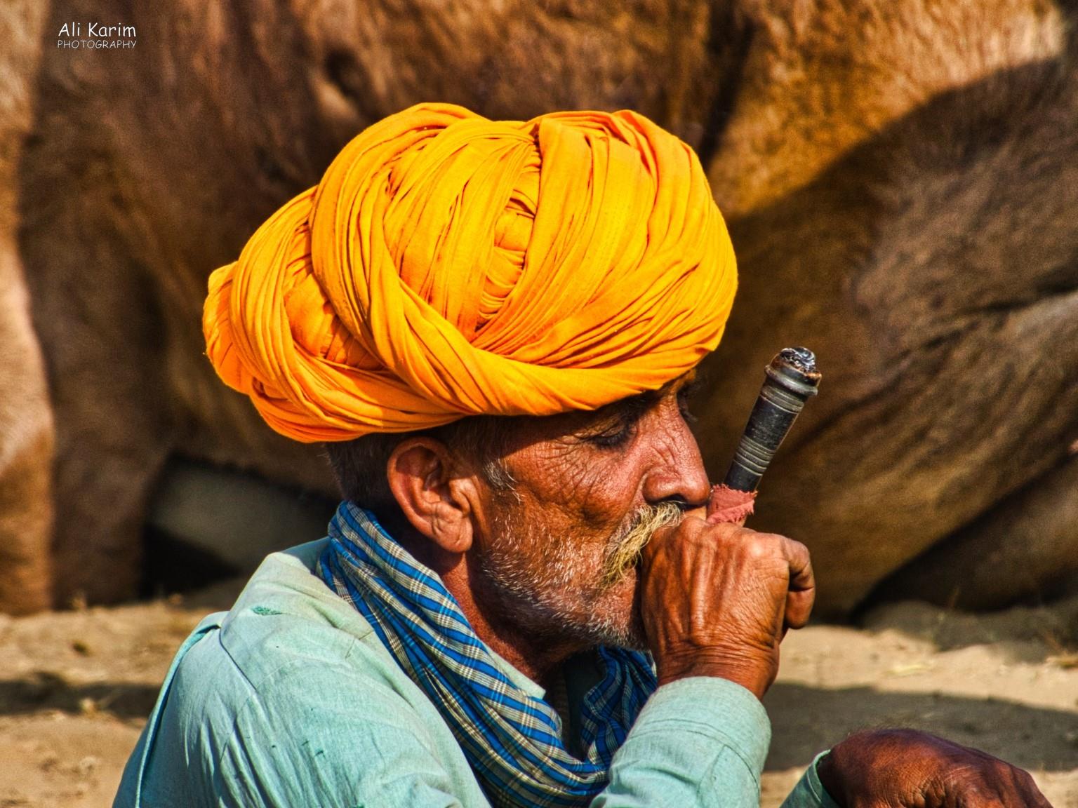 Passing the time smoking, while waiting for buyers for their camels Pushkar, Rajasthan Passing the time smoking, while waiting for buyers for their camels