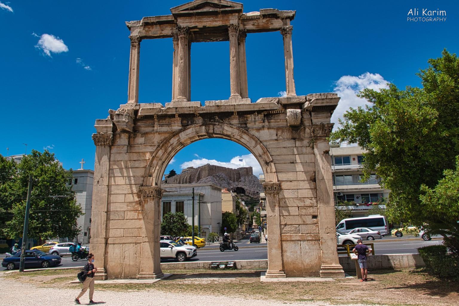 You are never far from a site of ruins anywhere in downtown Athens. Note the Acropolis and Parthenon view in the background under the arch More Athens, Greece, May 2021, You are never far from a site of ruins anywhere in downtown Athens. Note the Acropolis and Parthenon view in the background under the arch