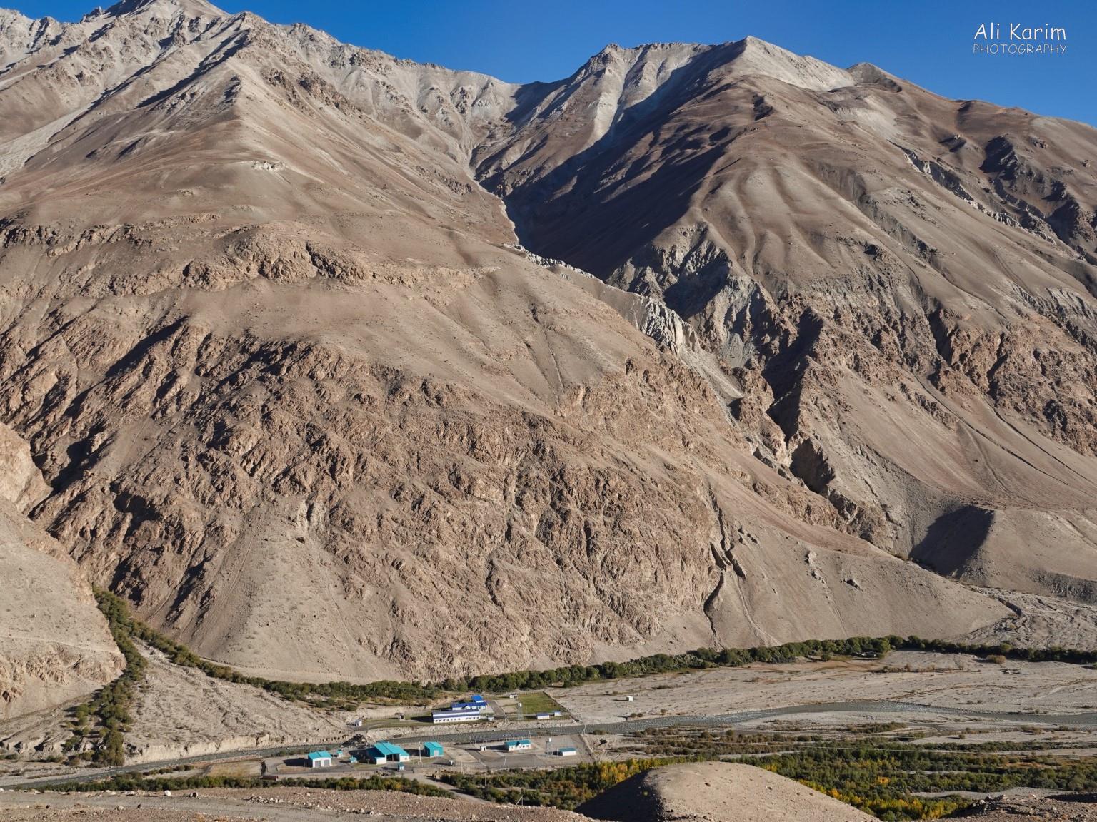 Tajik military post (green roofs) and Afghan military post (blue roofs) face each other across the Panj river Langar, Tajikistan, Tajik military post (green roofs) and Afghan military post (blue roofs) face each other across the Panj river