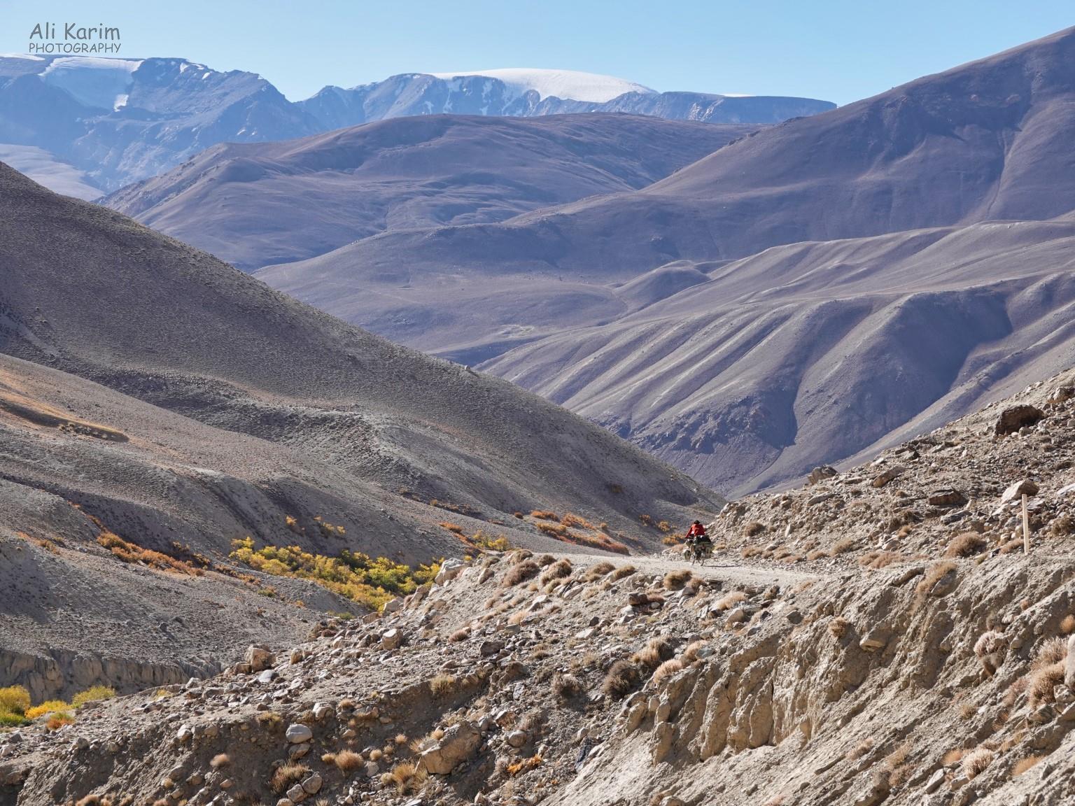 Lone biker in remoteness; probably happy its downhill Langar, Tajikistan, Lone biker in remoteness; probably happy its downhill