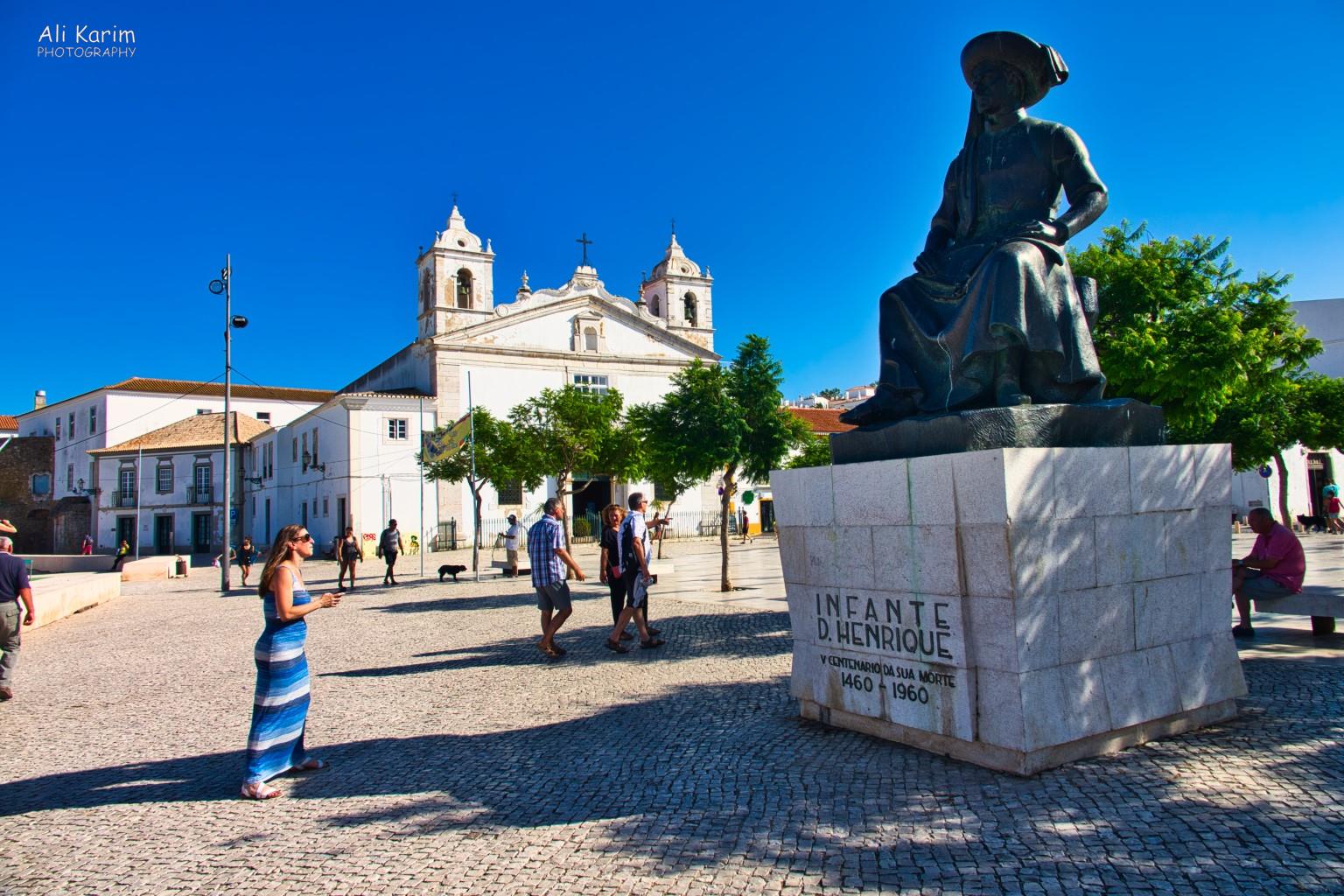 Henry the Navigator statue in the main square in downtown Lagos, complete with cathedral Algarve, Portugal Henry the Navigator statue in the main square in downtown Lagos, complete with cathedral
