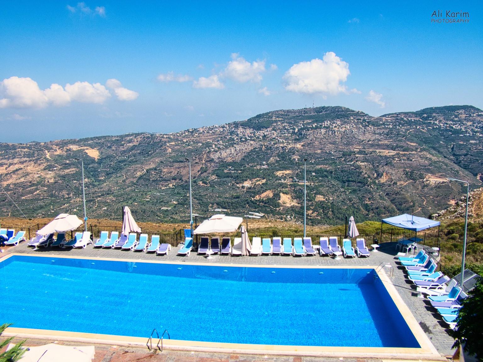 Hotel and restaurant, with small towns across on the other side of the valley on the mountain-sides Druze and the Chouf Mountains Hotel and restaurant, with small towns across on the other side of the valley on the mountain-sides
